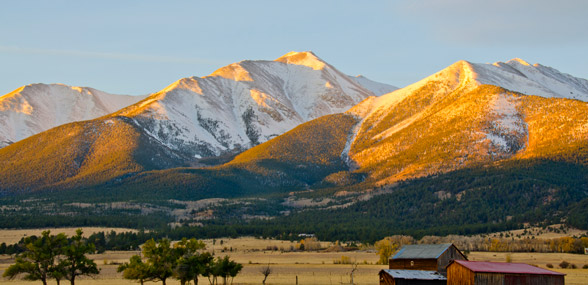 beautiful mountains at sunset with snowcapped peaks and a glow of amber